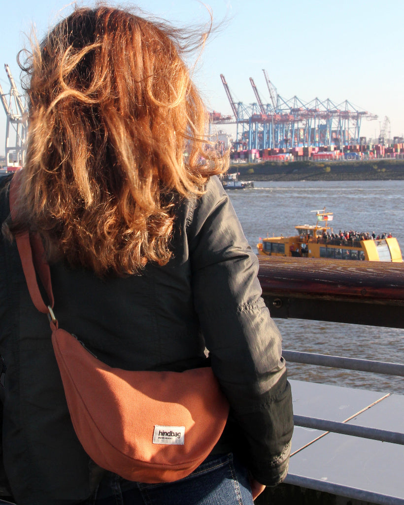 A woman with a Hindbag looking at a harbour